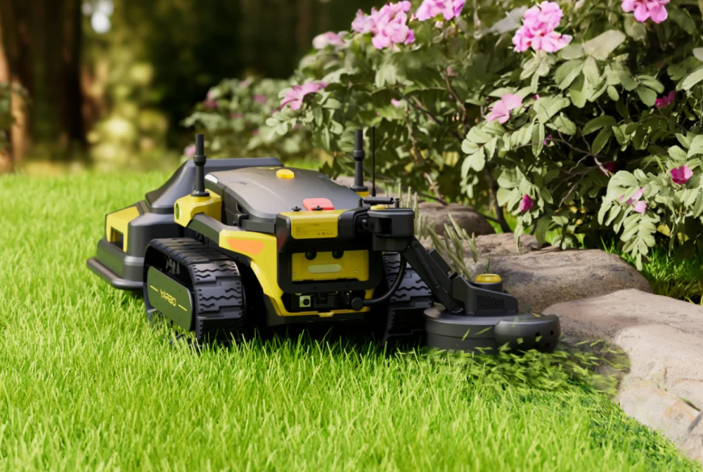 Yarbo Trimmer on grass with flowers and rocks in the background