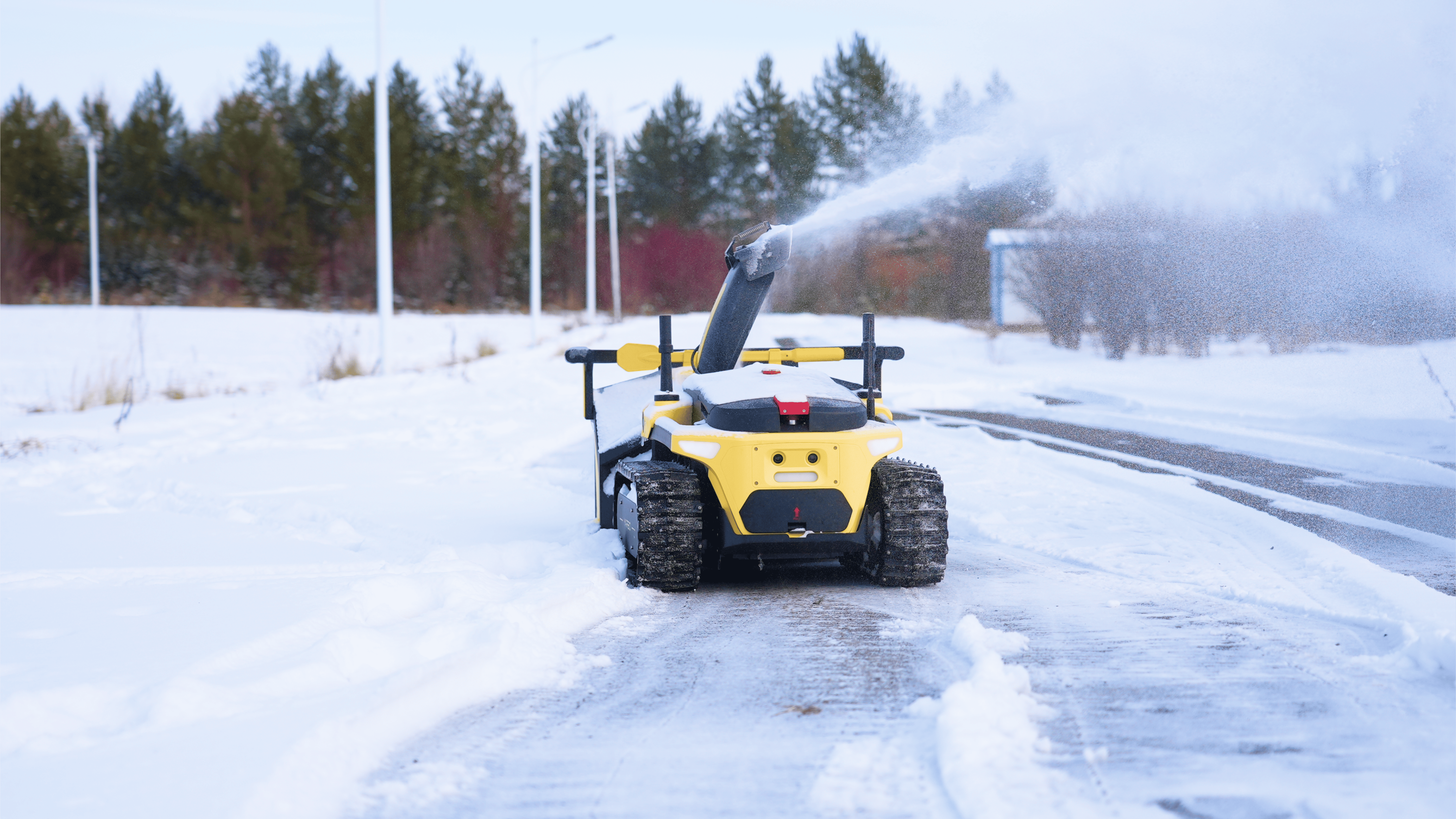 A snow removal robot clearing snow from a sidewalk during winter.