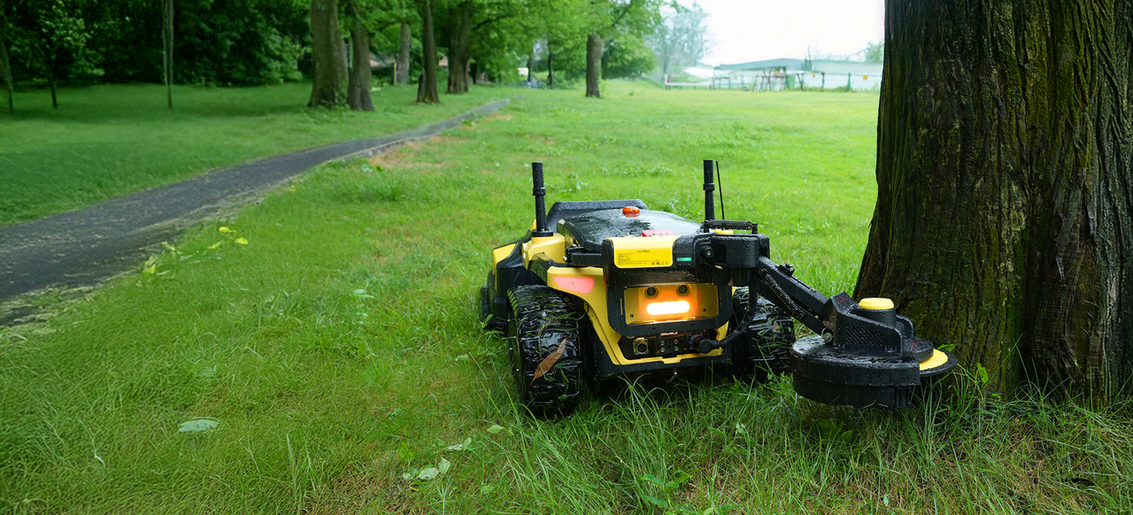 Yarbo Trimmer trimming next to a tree in a park setting