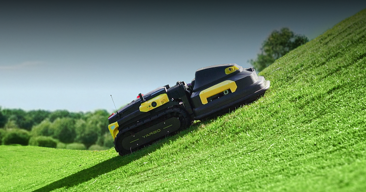 Yarbo lawn mower climbing a 70% (35°) steep slope, demonstrating all-terrain capability on rough and hilly ground