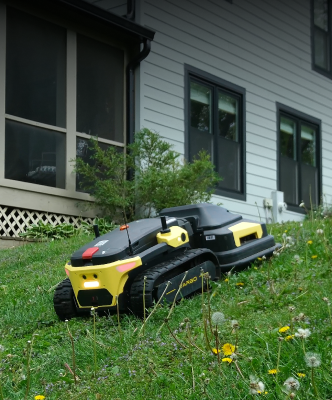 Yarbo robot lawn mower navigating a steep slope next to a house